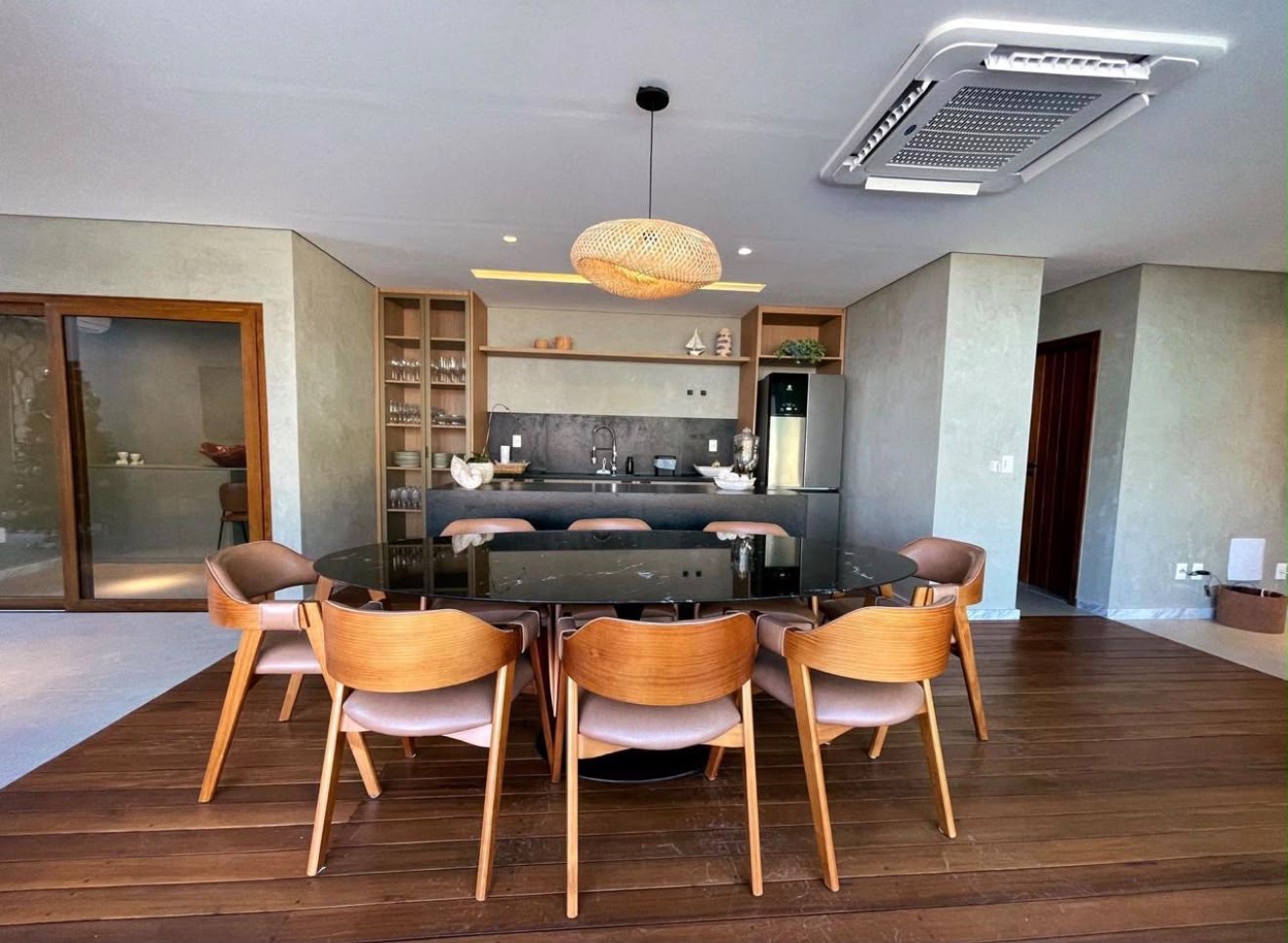 Mesa de jantar em pedra com a cozinha equipada ao fundo